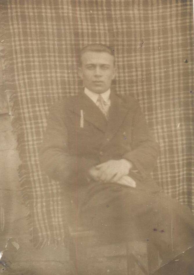 Фото черно – белое: Портрет юноши в костюме, белой рубашке с галстуком. Сидит на стуле. Надпись с обратной стороны: 4 -39 г. 9 кл. Задерковский.