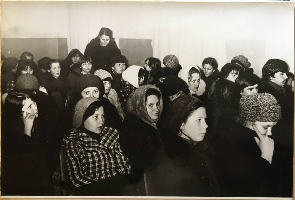 Фото черно-белое горизонтальное. На снимке в зале сидят  на откидных стульях, которые расставлены рядами, женщины.