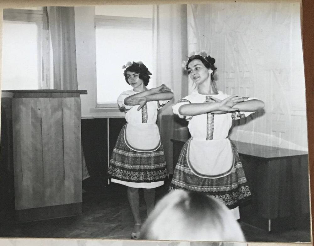 Фото черно- белое, горизонтальное. На фото  две девушки в  национальных костюмах.