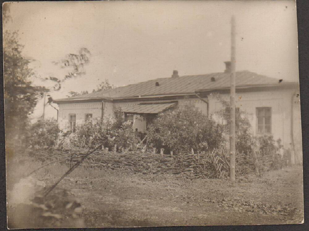 Фото. Кирпичный дом с палисадником обнесенным плетнем