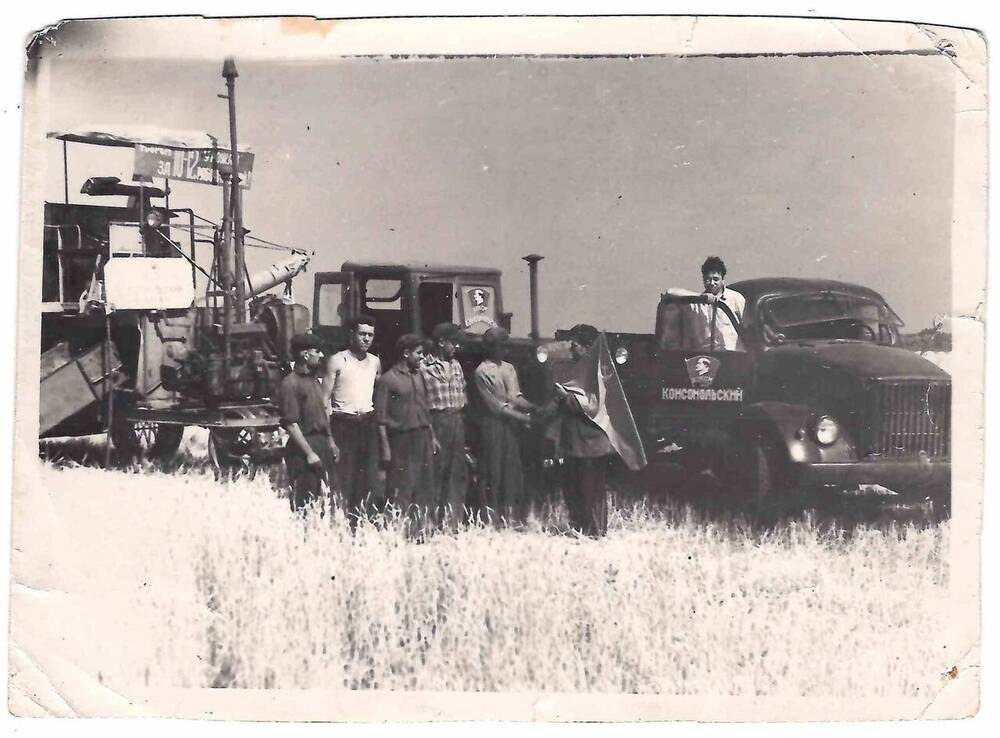 Фотография черно-белая. На поле пшеницы группа мужчин.