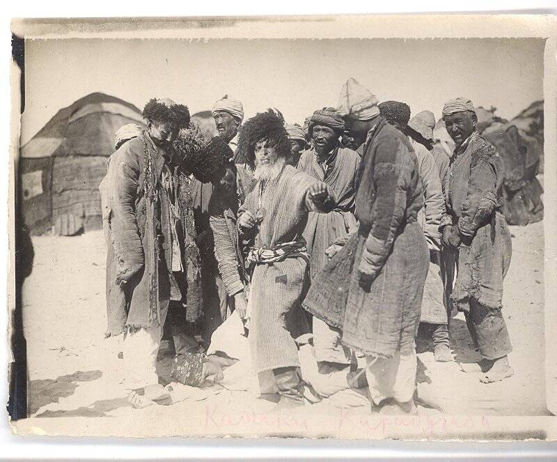 Фотография ч/б. Съемка фильма «Черная пасть» (реж. А.Разумный). Группа казаков около своих жилищ в пустыне. 1935 г.