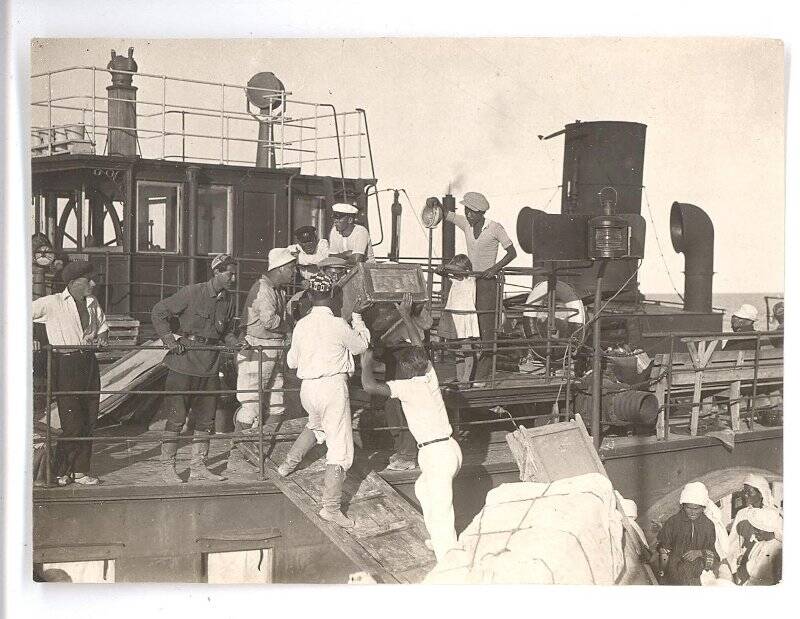 Фотография ч/б. Съемка фильма «Черная пасть» (реж. А.Разумный). Рабочий момент - члены съемочной группы загружают на корабль мебель. 1935 г.