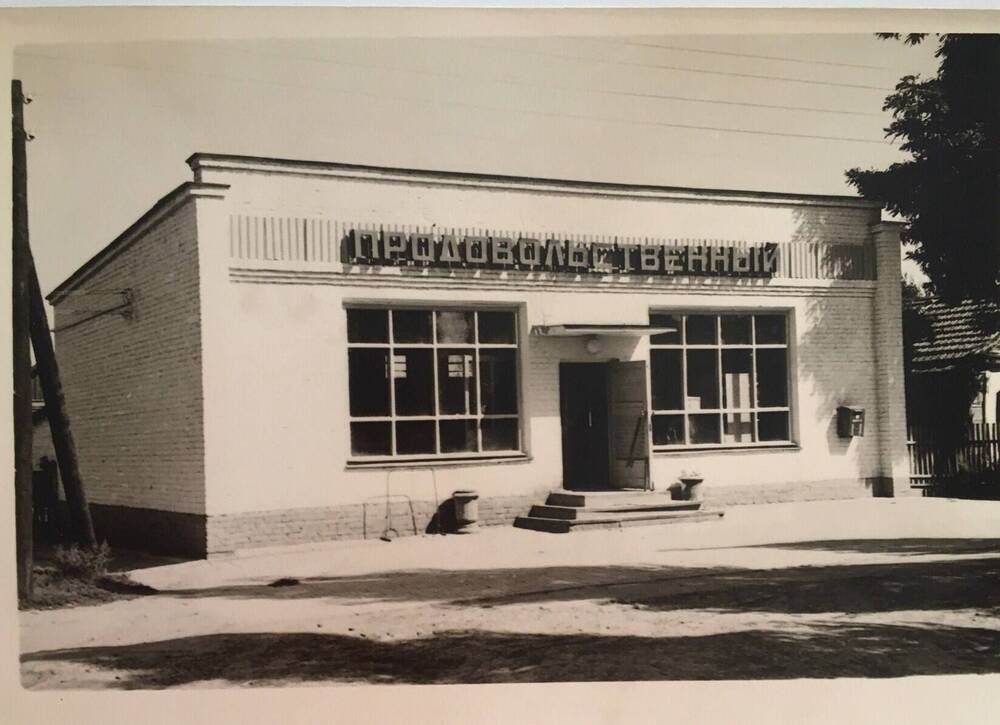 Фото черно-белое, горизонтальное.  На фото здание продовольственного магазина по ул.Фрунзе г.Кореновска