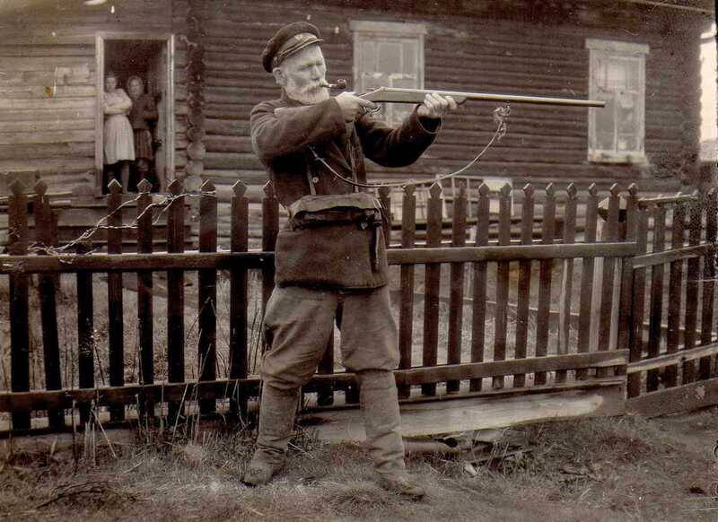 Фотография сюжетная. Макаров Николай Павлович с ружьём в руках возле своего дома в посёлке Галка, 1950-е годы.