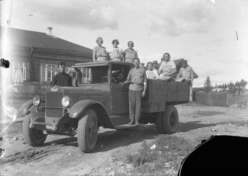 Негатив. Группа мужчин и женщин на грузовом автомобиле.