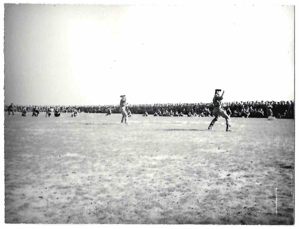 Фотография черно-белая. На открытом поле демонстрация боевых искусств.