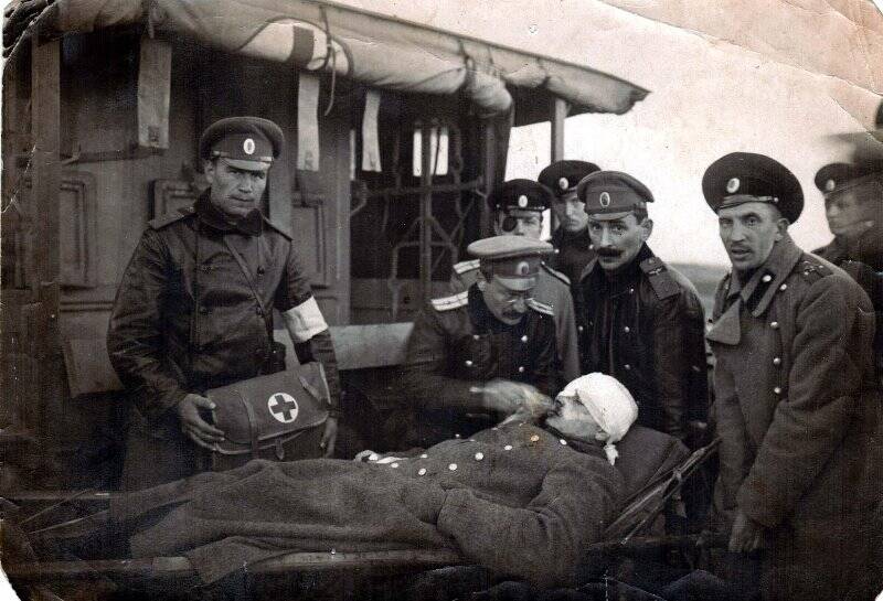 Фотография. Пшенников Н.Г. в группе офицеров царской армии около раненного. 1916 г.