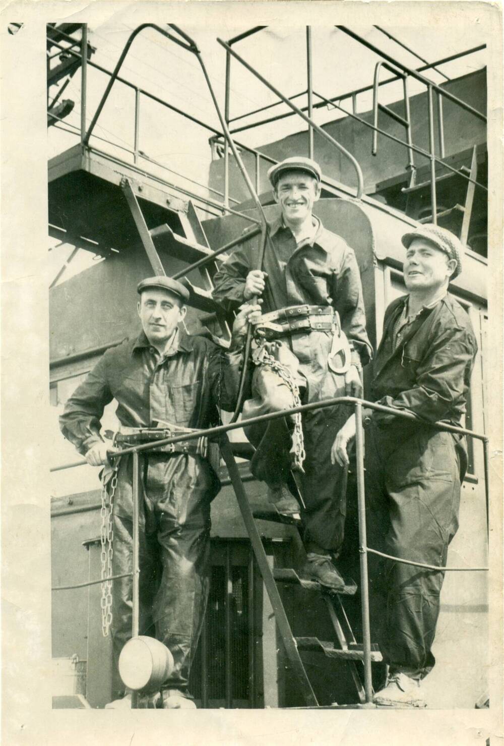 Фотография чёрно-белая: на рабочей дрезине трое железнодорожников.