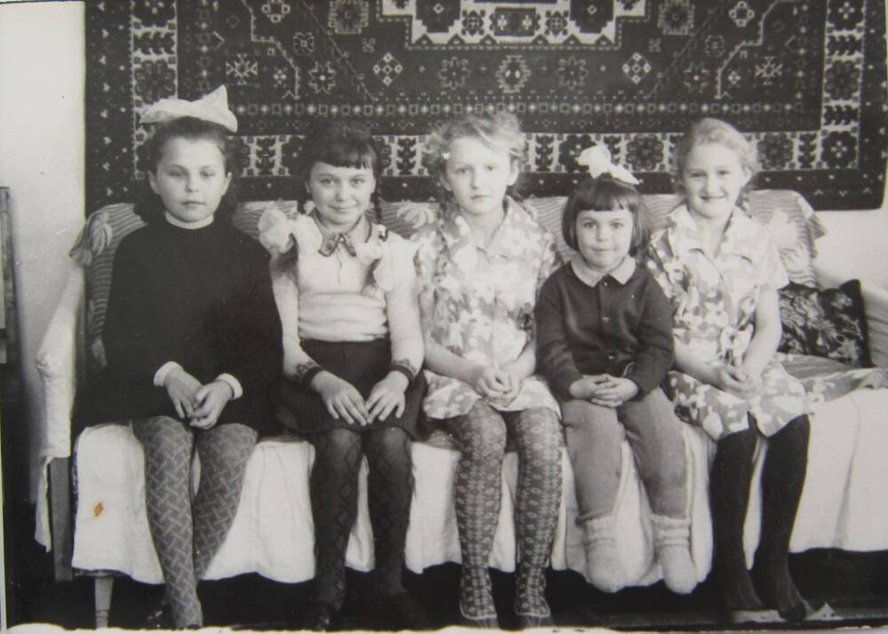 Фотоснимок. На фото 5 девочек сидят на диване. На заднем плане виден ковёр на стене . 60-е гг. СССР.   
Коллекция фотографий 40-50-х годов, собранная 
Березнёвой М. А.