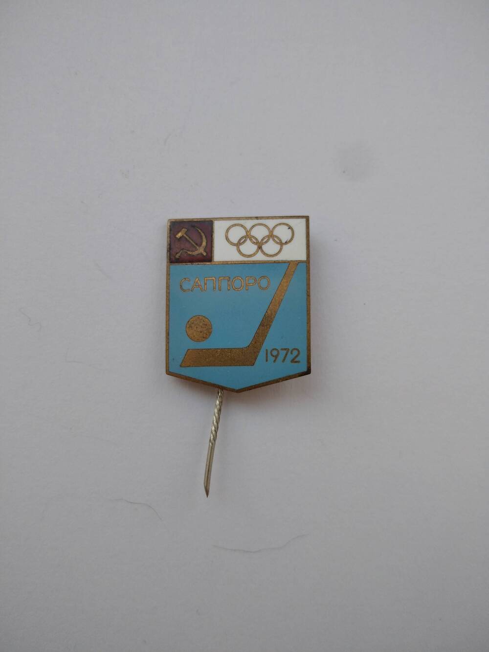 Значок пятиугольный с надписью: Саппоро.1972 с изображением пяти олимпийских колец.
