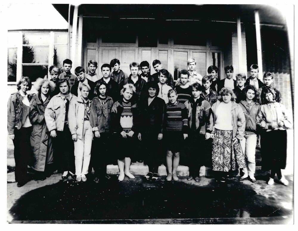 Фотография черно-белая, групповая. На снимке у входа в здание изображены студенты профтехучилища № 70 с преподавателем. Во втором ряду 4-й слева Коваль И.Н.