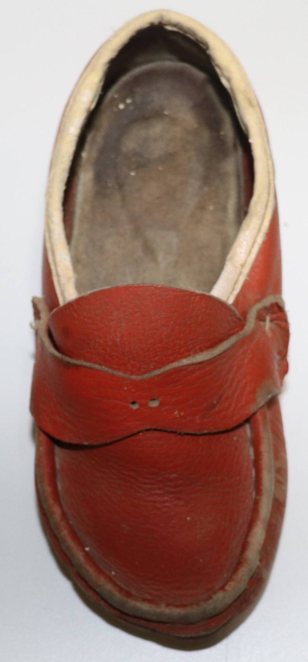 Туфля из кожзама красного цвета с белой окантовкой. Часть пары, правая.