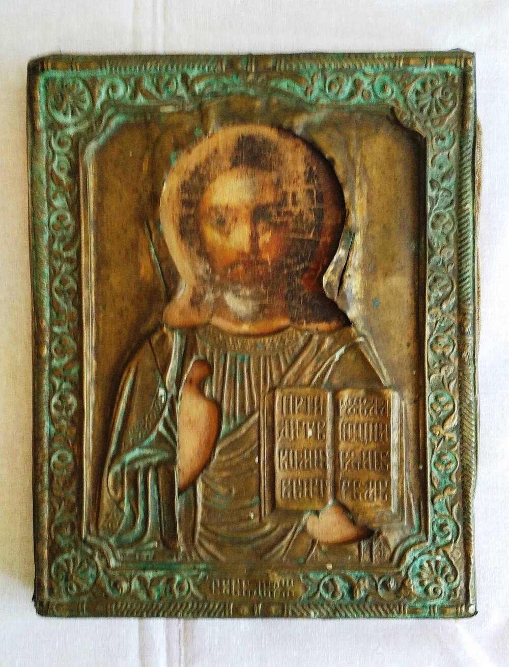 Икона Иисуса Христоса, написанная на дереве, в металлической рамке.