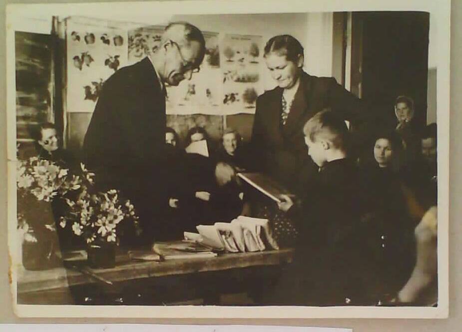 Фотография. Групповой портрет. Директор Мугайской школы Толмачев С.С. вручает подарки юным юннатам.