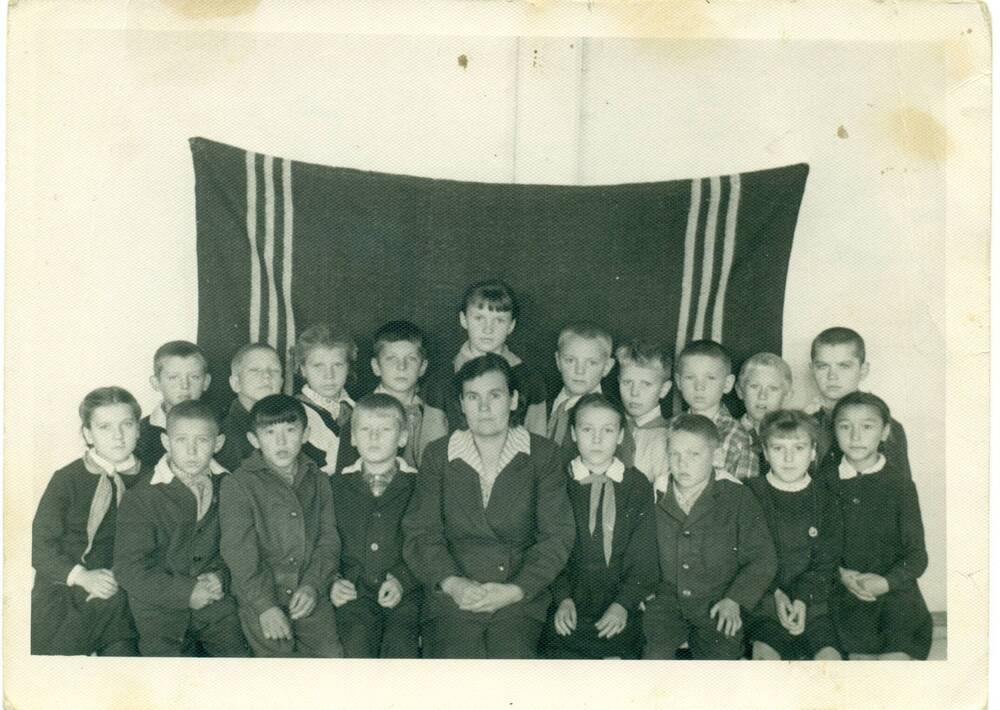 Фотография чёрно-белая: групповой снимок, в центре учительница Кононова Прасковья Васильевна.