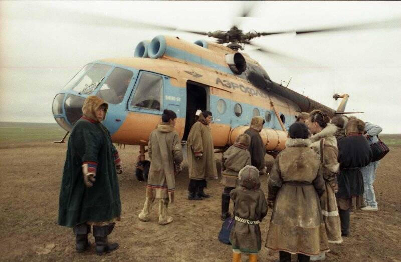 Оленеводы встречают гостей, прилетевших на вертолёте в тундру. Негатив