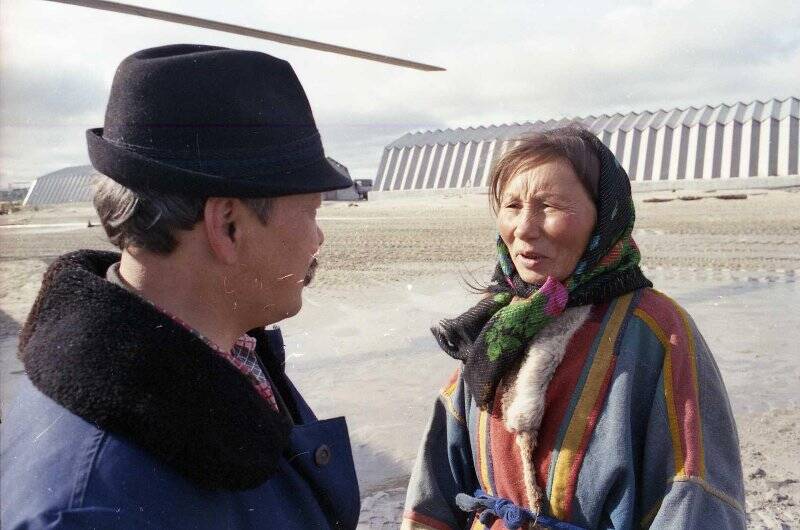 Яунгад Х.Х. (слева) беседует с женщиной на вертолётной площадке Салехардского аэропорта. Негатив