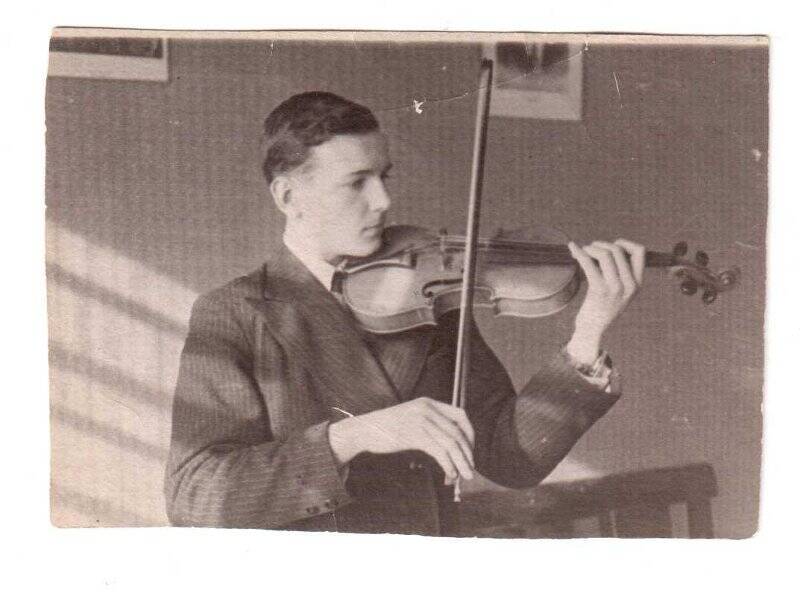 Фотография черно-белая. Кобжув Вячеслав Петрович играет на скрипке.