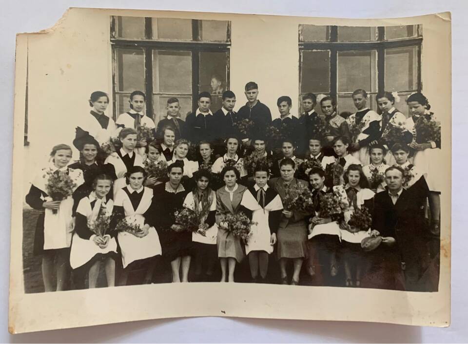Фотография черно-белая групповая. Ученики 5 класса в парадной школьной форме, некоторые с пионерскими галстуками и преподаватели возле школы-интерната № 7. Сев-Кав ж. д. ст. Кавказская, 60-е годы.