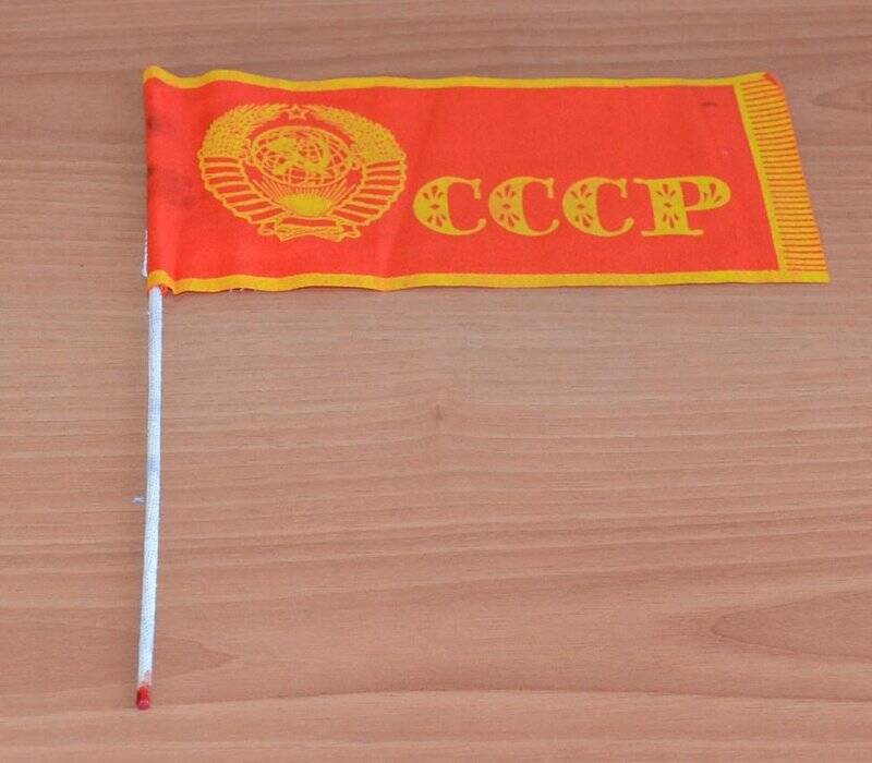 Флажок  СССР красного цвета. На флажке  слева изображен герб Советского Союза и надпись « СССР» Крепится на палочку