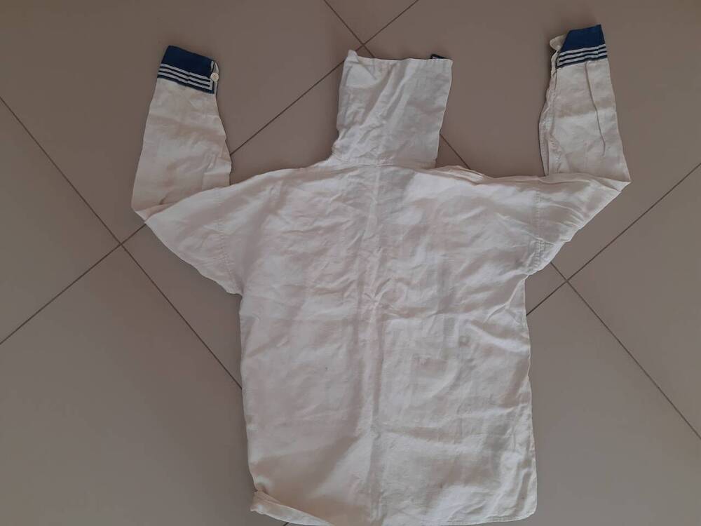 Рубаха мужская белого цвета (форменка) -  часть флотского костюма - с большим форменным воротником синего цвета (с тонкими полосками белого цвета), рукавами с манжетами. Размер предполож.50-52-й. Коллекция предметов одежды из эпохи 1980-х гг. 