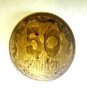 Монета украинская. Достоинством  50 коп. Круглой формы. Желтого цвета.