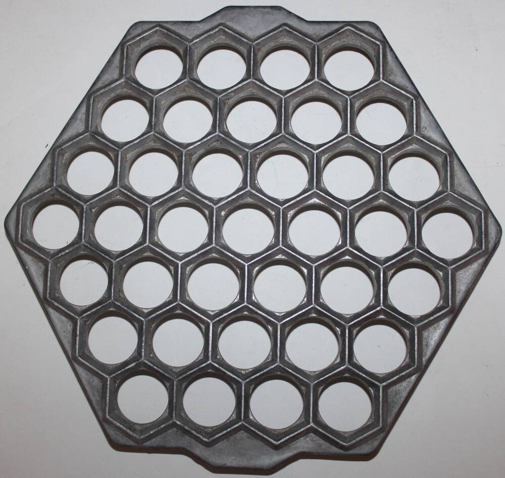 Форма алюминиевая шестиугольная, на маленьких ножках, с 37 отверстиями применялась для изготовления пельменей.