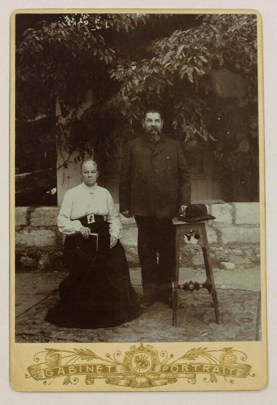 Фото на паспарту. Портрет неизвестных мужчины и женщины возле дома.