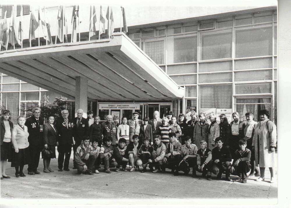 Фото ч/б, глянцевое, групповое. Встреча ветеранов делегация на фоне здания «Химик» 1988г.