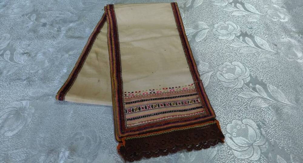 Сурпан (головная повязка) из белого полотна, края и концы украшены вышивкой.
