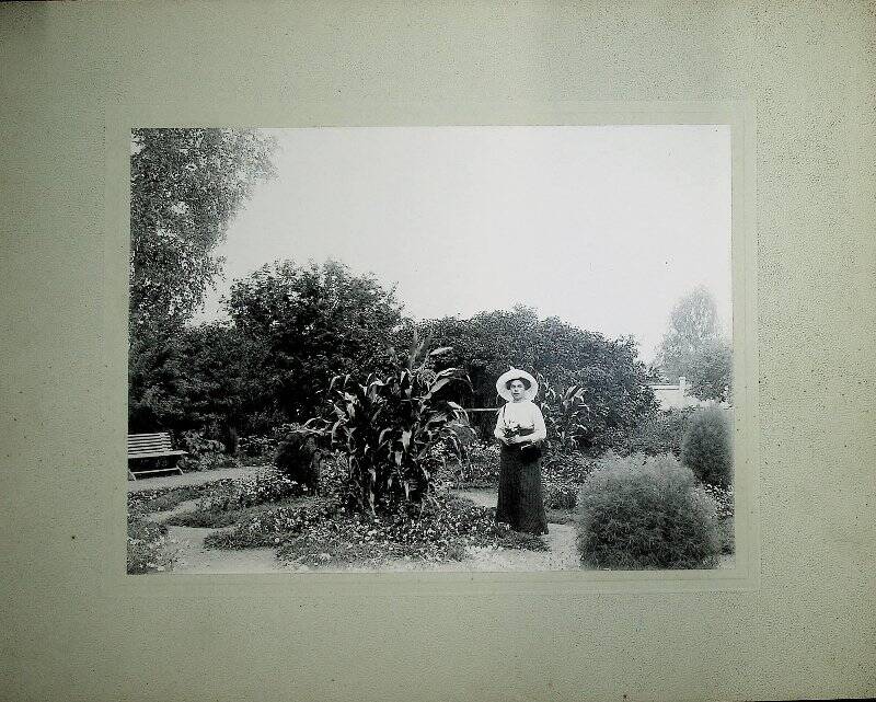 Фотография. О.М.Пушкина (Зеленина) в цветнике возле дома управляющего, 1912 г.