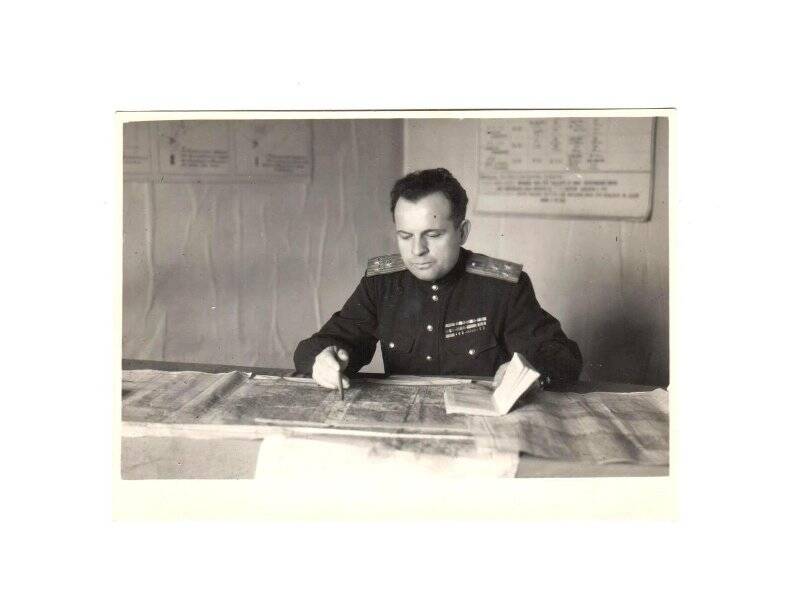 Фотопортрет. В.С. Лебедев за рабочим столом с книгой и ручкой в гимнастёрке с погонами полковника.