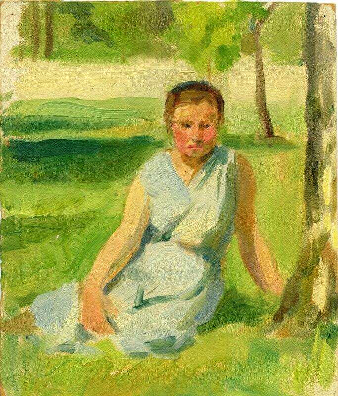 Девушка, сидящая на траве.