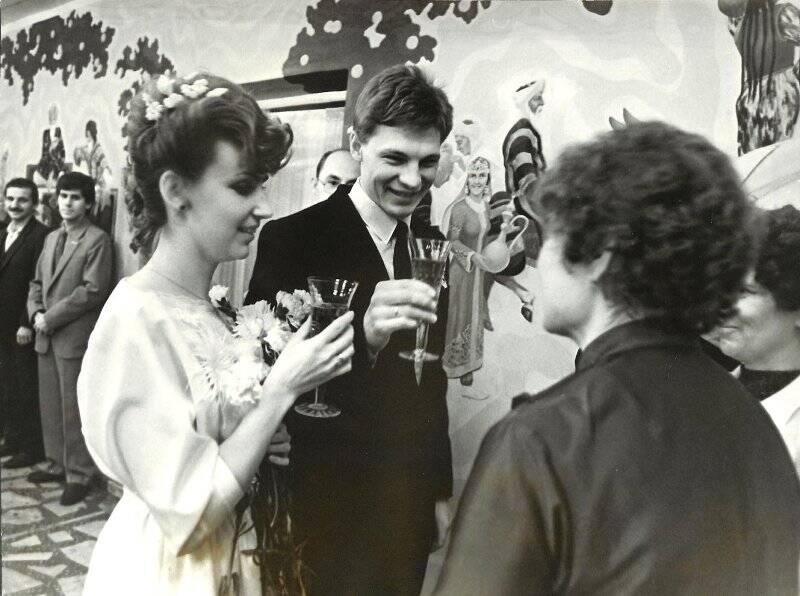 Фотография черно-белая. Групповой снимок. Свадьба: Жених и невеста поднимают бокалы с шампанским.