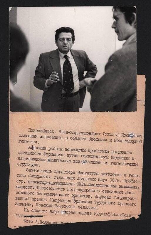 Фотография черно-белая. Темноволосый мужчина в брючном костюме (член-корр. АН СССР Р. И. Салганик), стоит подбоченившись левой рукой.