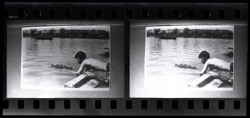 Негатив черно-белый, сюжетный. Соревнования по судомодельному спорту. Мальчик спускает на воду кораблик. 1960-е гг.