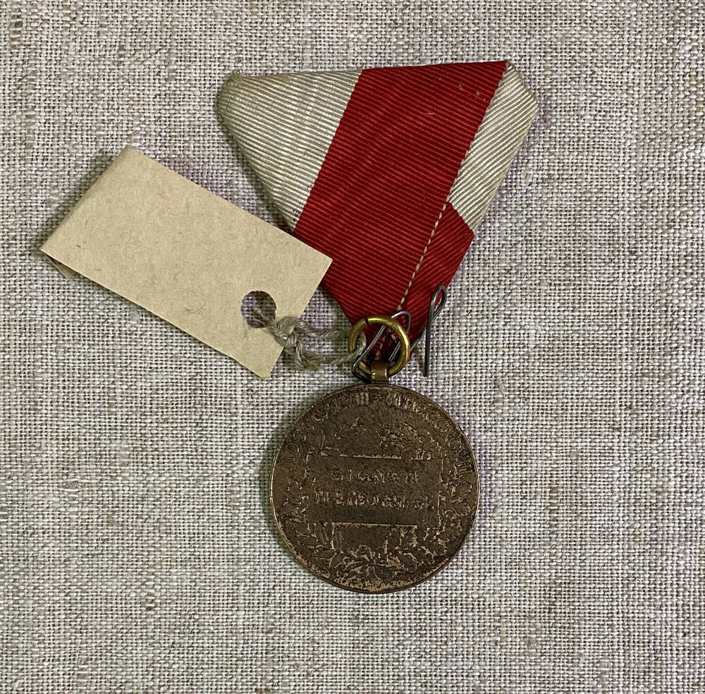 Медаль круглой формы Австро-Венгерской империи с изображением силуэта короля, на муаровой ленте