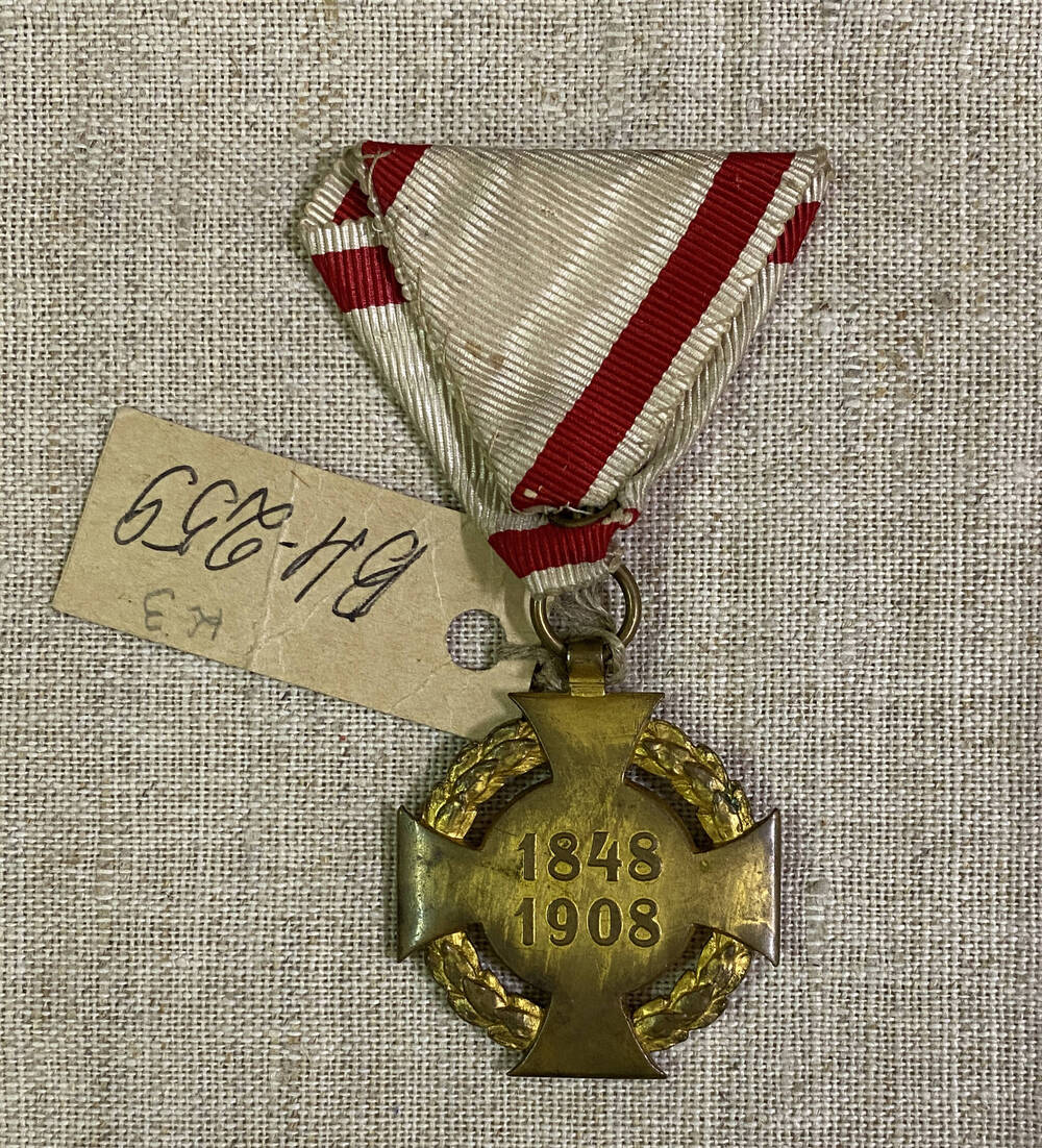 Медаль круглой формы Австро-Венгерской империи , на аверсе изображен силуэт человека в обрамлении лаврового венка, на реверсе цифры: 1848 1908 , муаровой ленте
