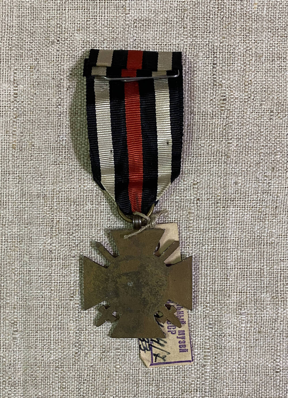 Орден Австро-Венгерской империи в форме креста, цифры 1914 1918 в обрамлении лаврового венка и двух перекрещивающихся шпаг. На муаровой ленте