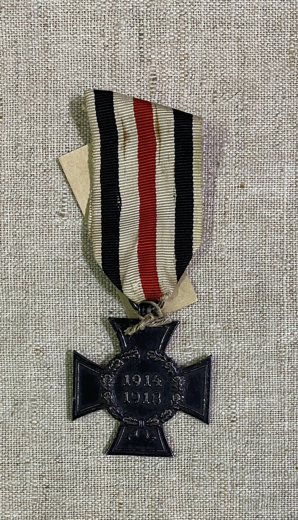 Орден Австро-Венгерской империи в форме креста, цифры 1914 1918 в обрамлении дубового венка. На муаровой ленте