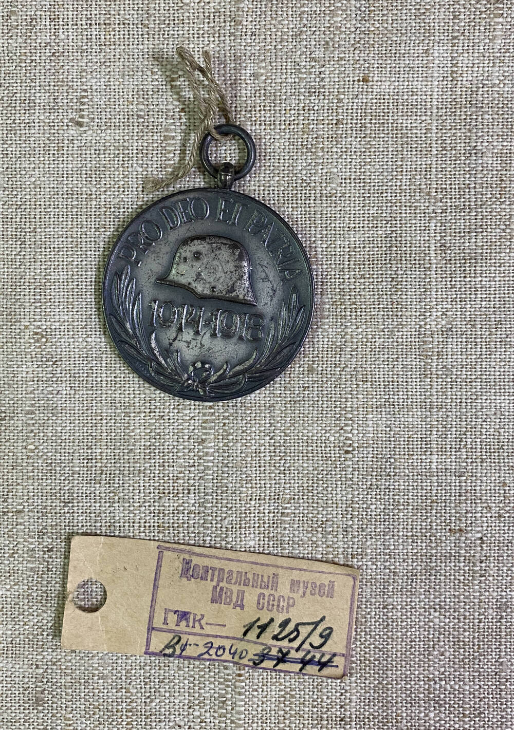Медаль круглой формы Австро-Венгерской империи , на аверсе изображена каска и цифры 1914-1918, текст, на реверсе герб, корона и перекрещивающиеся мечи в обрамлении лавровых листьев
