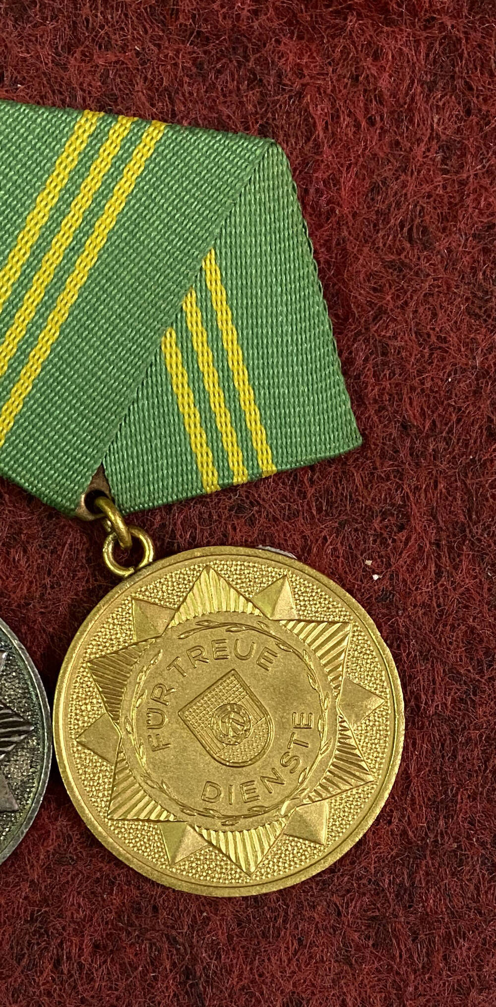 Медаль ГДР За верную службу I ст. круглой формы, с изображением гос.эмблемы, текст - на аверсе; на реверсе гос. эмблема в обрамлении стеблей колосьев, крепление булавочное