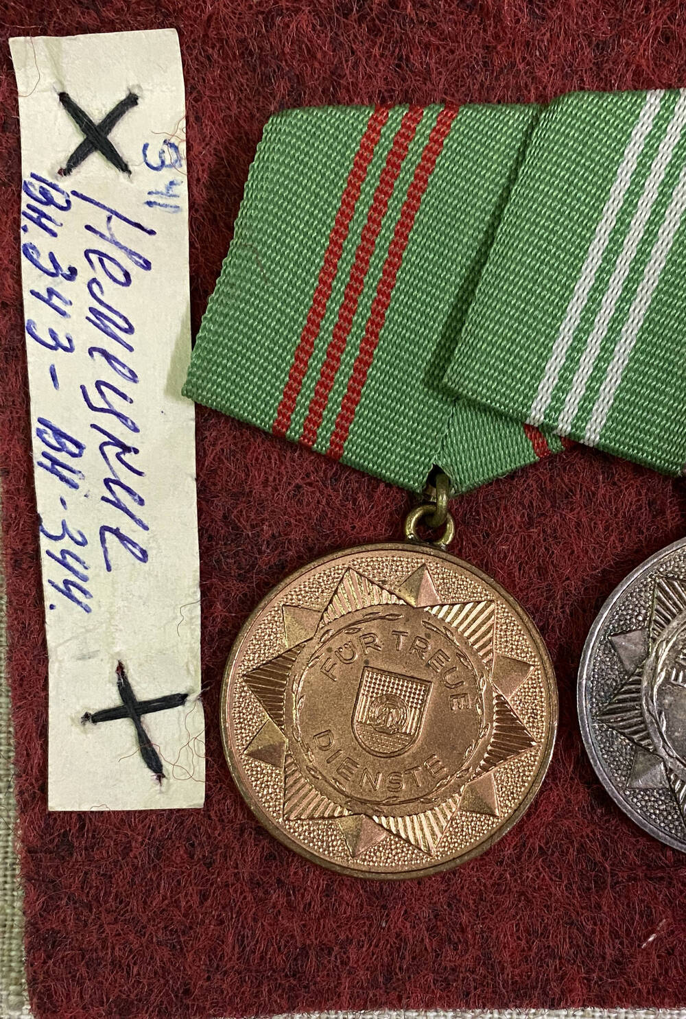 Медаль ГДР За верную службу круглой формы, с изображением гос.эмблемы, текст - на аверсе; на реверсе гос. эмблема в обрамлении стеблей колосьев, крепление булавочное