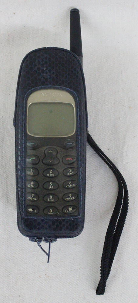 Сотовый телефон NOKIA - 650 в чехле.