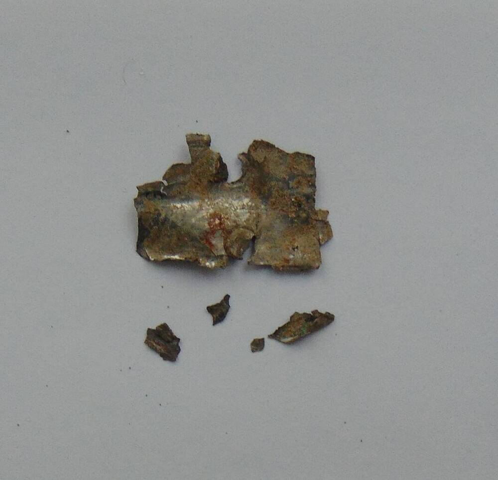 Накладка во фрагменте неправильной формы с двумя отверстиями. Клин-Яр-III, п.357, заполнение входной шахты.