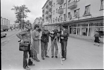 Группа с киносъемочным аппаратом на улицах города, на предприятиях