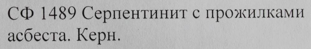 Образец горной породы. Серпентинит с прожилками асбеста.