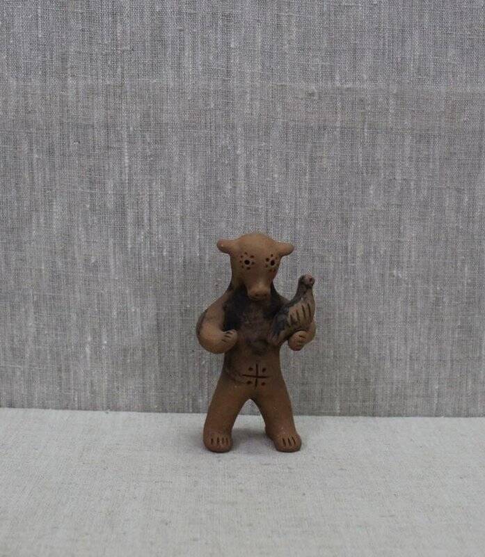 Каргопольская глиняная игрушка «Медведь с птицей».