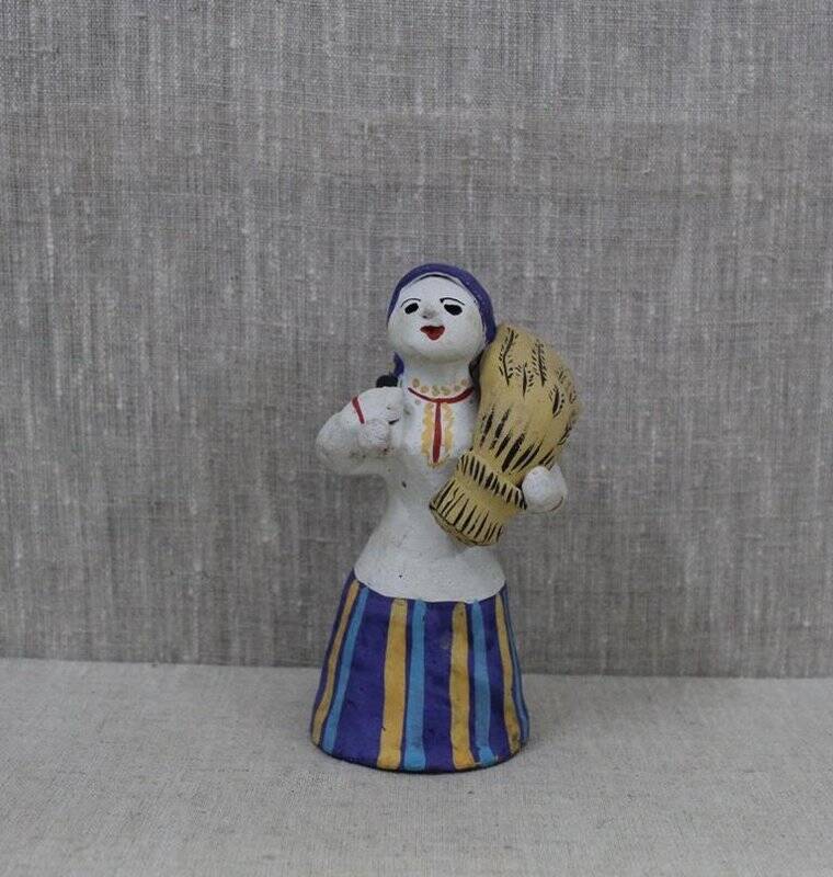 Каргопольская глиняная игрушка «Баба со снопом и серпом».